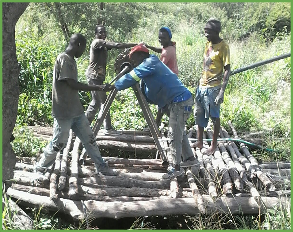 Young men getting water from a well